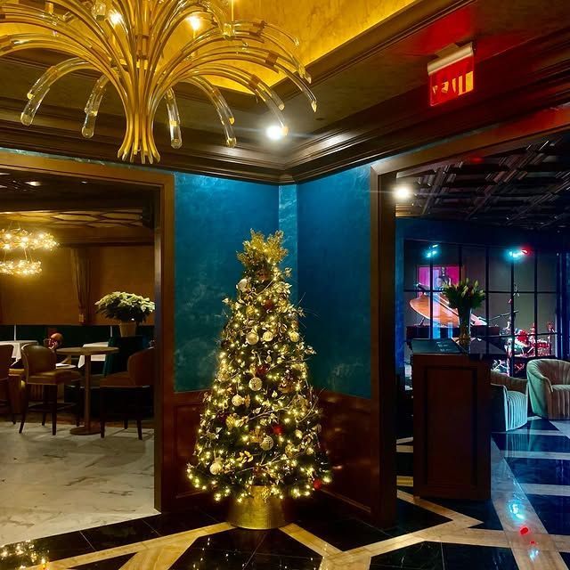 A christmas tree in a room with a red exit sign