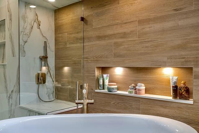 A bathroom with a bathtub , shower , and shelf.