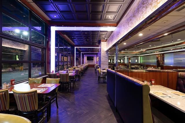 A long dining room with tables and chairs in a restaurant.