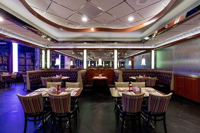 A restaurant with tables and chairs and a large window