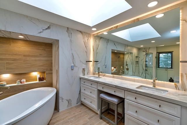 A bathroom with two sinks , a bathtub and a large mirror.