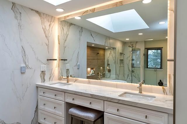 A bathroom with two sinks and a large mirror.