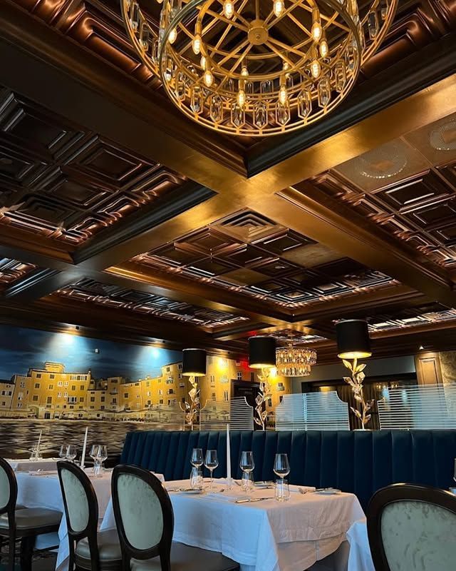 A restaurant with tables and chairs and a chandelier hanging from the ceiling