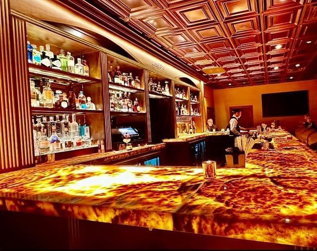 A long bar with a lot of bottles on it