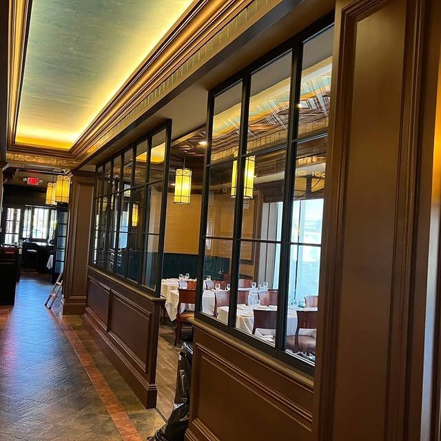 A long hallway in a restaurant with tables and chairs