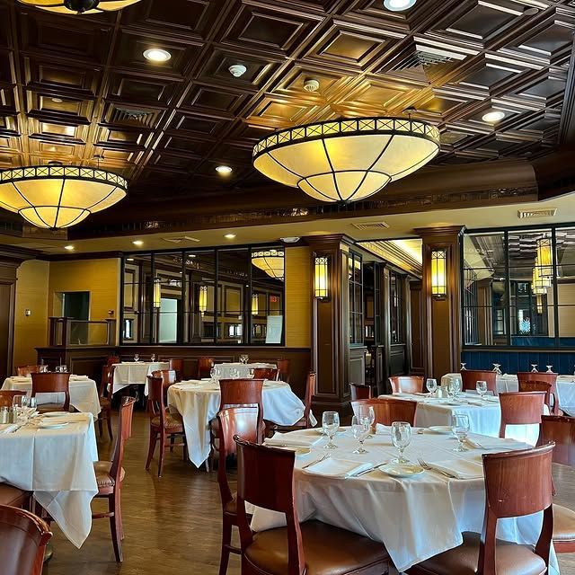 A large dining room with tables and chairs and lots of lights