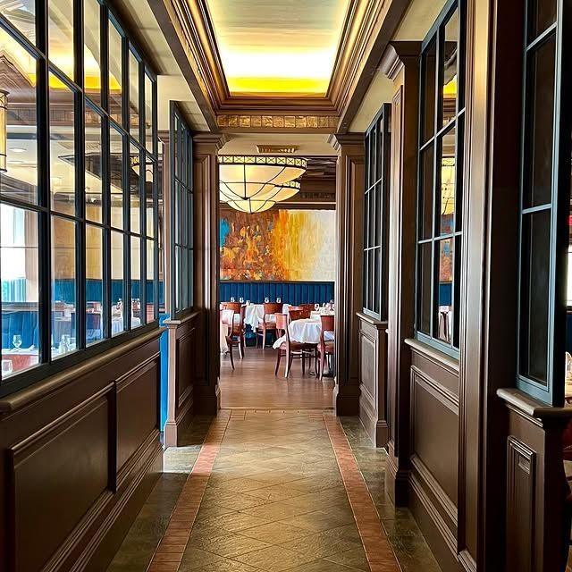 A long hallway in a restaurant with tables and chairs