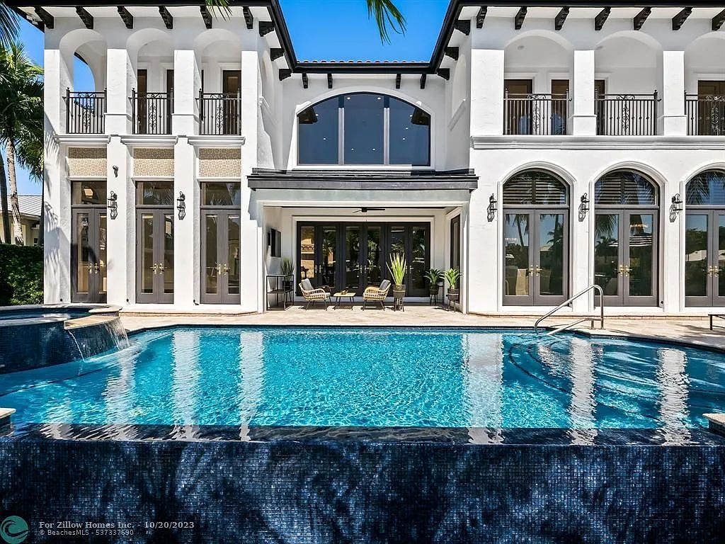 A large white house with a large swimming pool in front of it