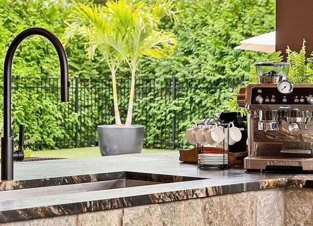 A kitchen with a sink and a coffee machine.