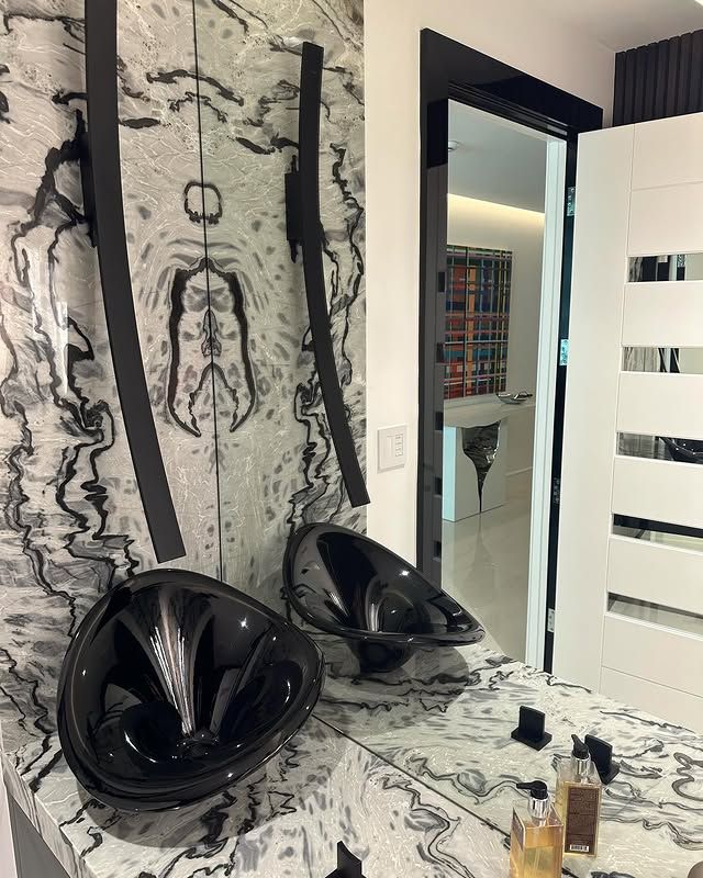 A bathroom with two black sinks and a mirror