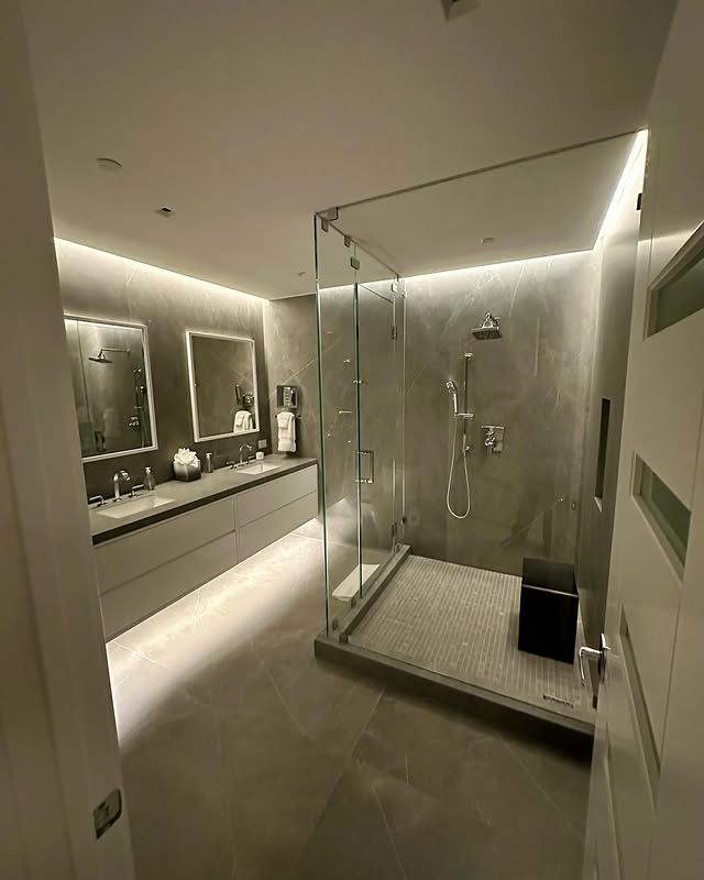 A bathroom with a walk in shower and two sinks.