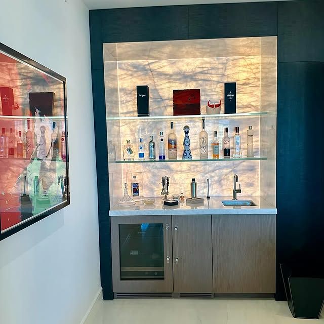 A bar with bottles on shelves and a sink