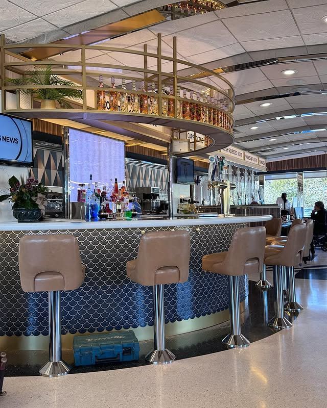 A restaurant with a bar and stools in front of it