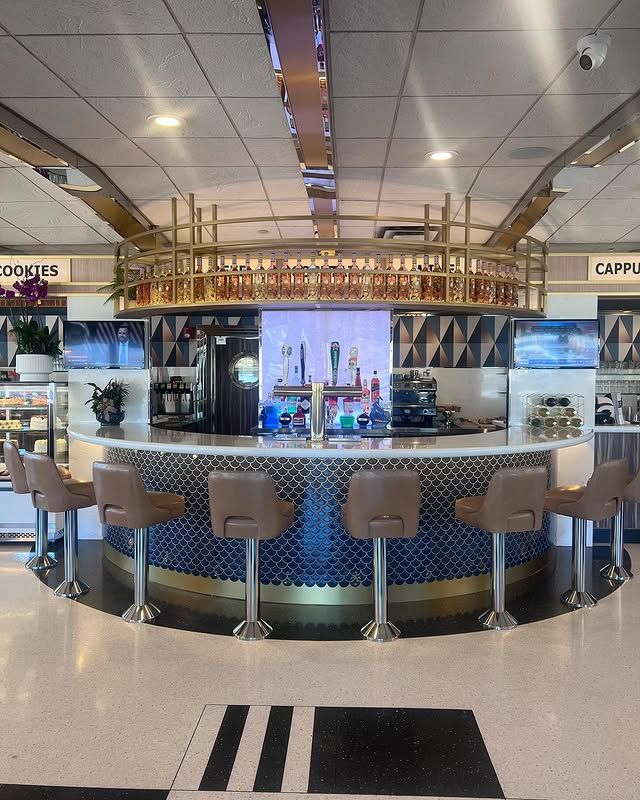 A bar with stools and a sign that says cappuccino