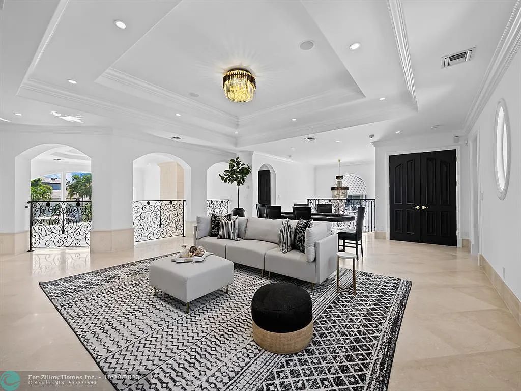 A living room with a couch , ottoman , and rug.