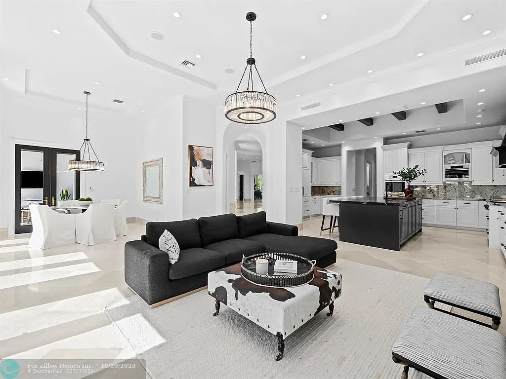 A living room with a black couch and a white coffee table.