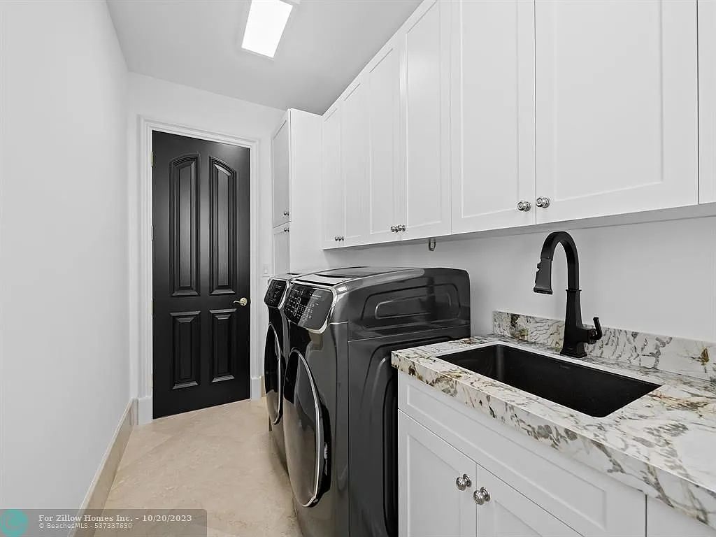 A laundry room with a washer and dryer and a sink.