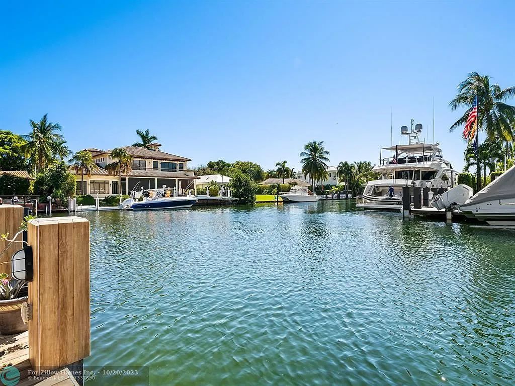 A large body of water with boats and a house in the background.