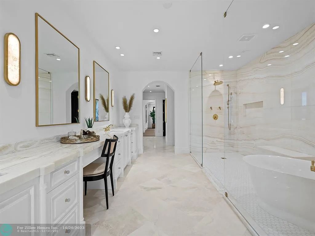 A bathroom with two sinks , a tub , and a walk in shower.