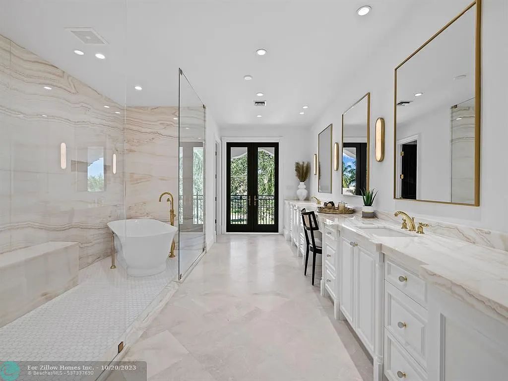 A bathroom with a tub , sinks , mirrors and a walk in shower.