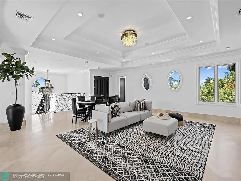 A living room with a couch , rug , table and chairs.