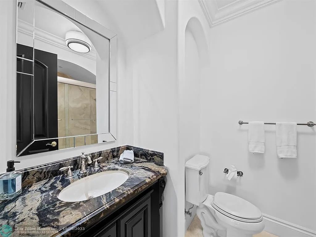 A bathroom with a sink , toilet and mirror.