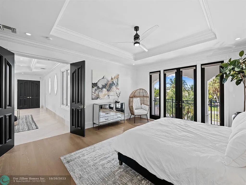 A bedroom with a large bed and a ceiling fan.