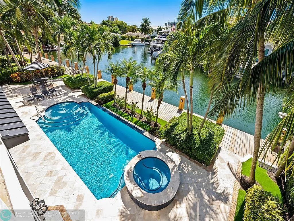 An aerial view of a large swimming pool surrounded by palm trees.
