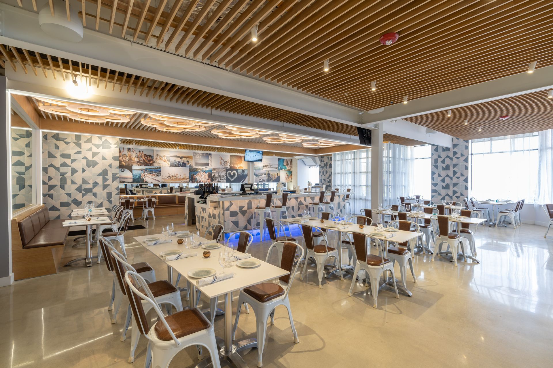 A large dining room with tables and chairs and a wooden ceiling.