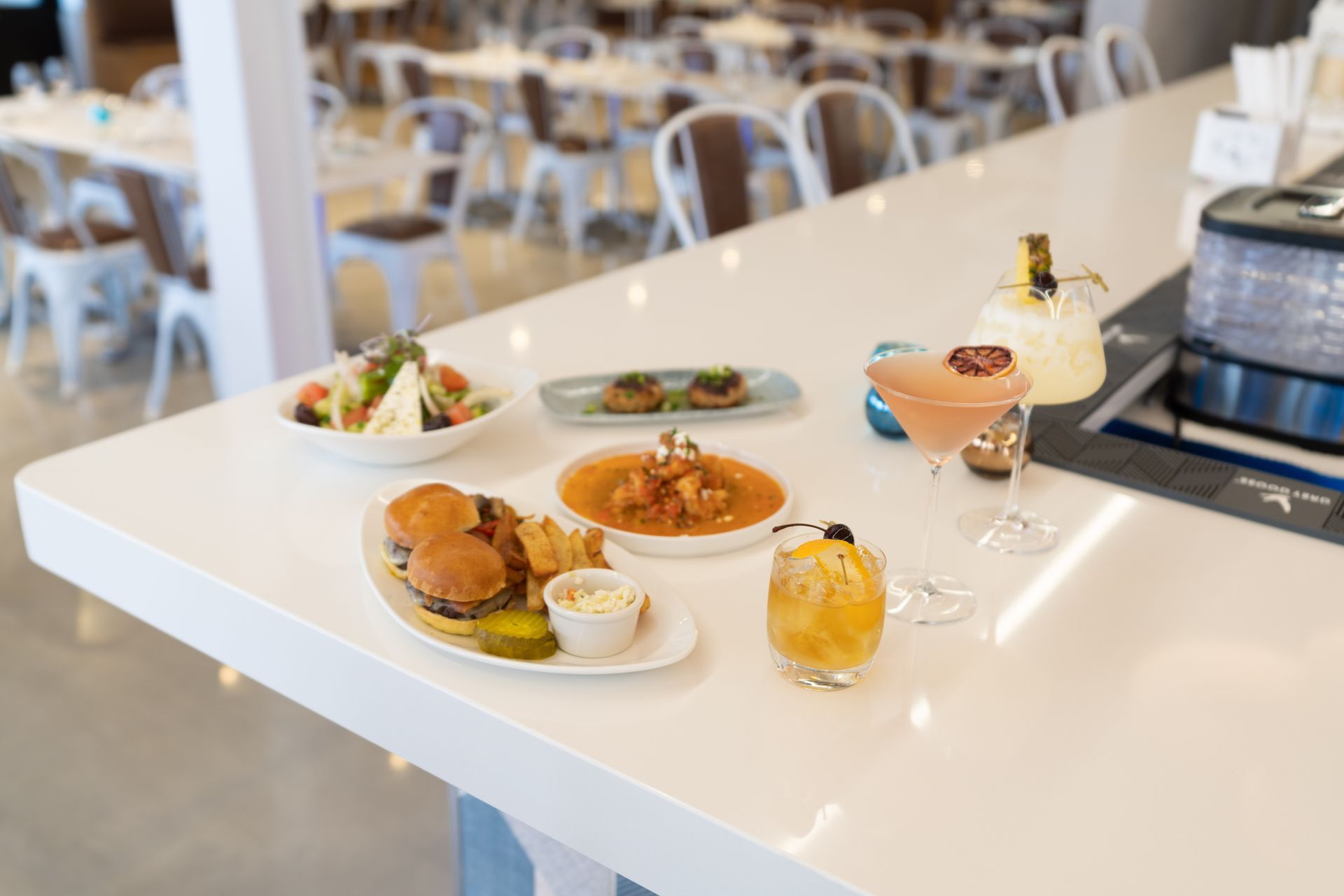 A table topped with plates of food and drinks in a restaurant.
