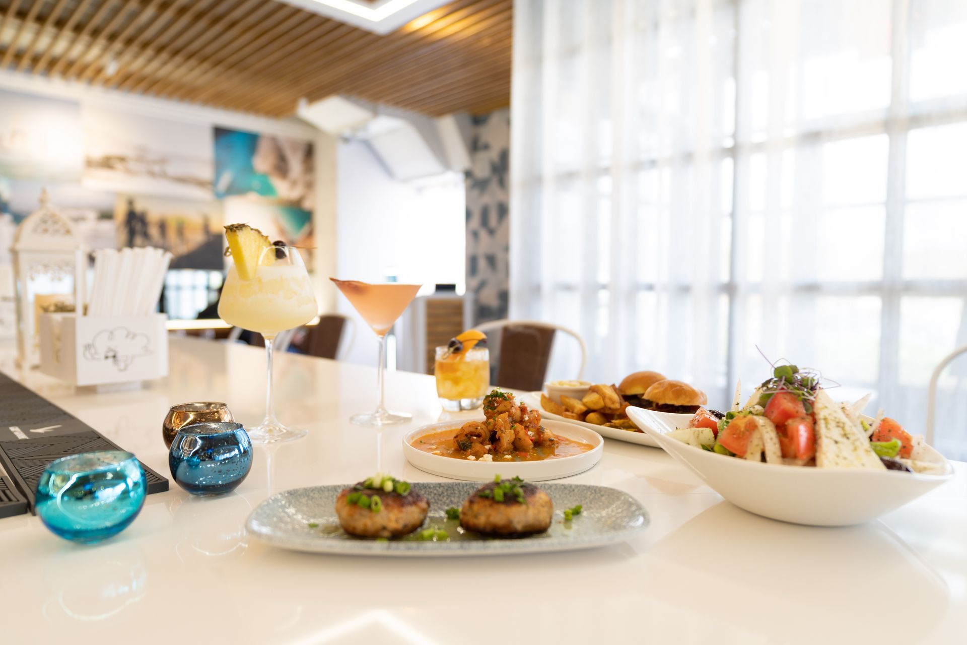 A table topped with plates of food and drinks in a restaurant.