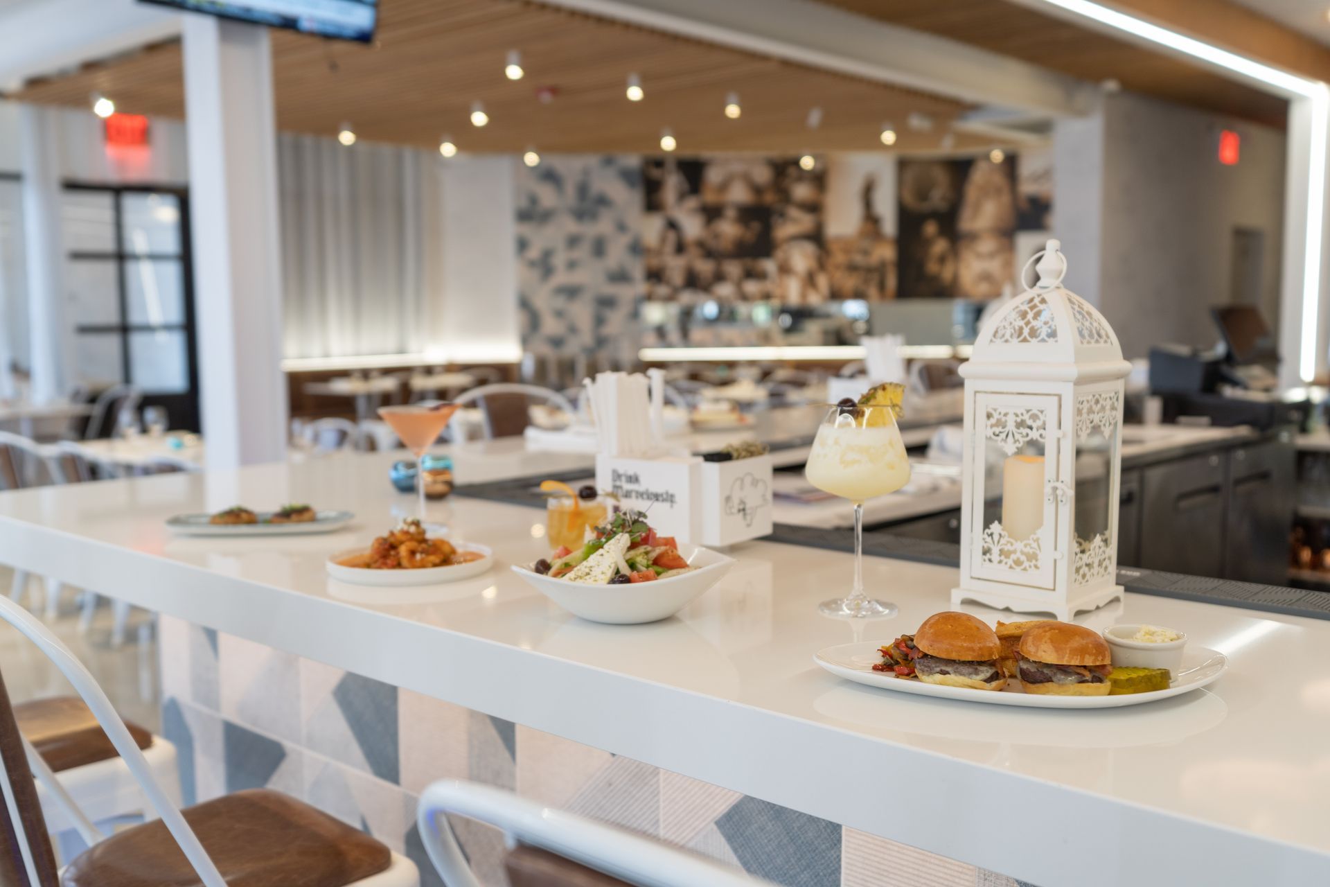 A restaurant with a bar and plates of food on it.