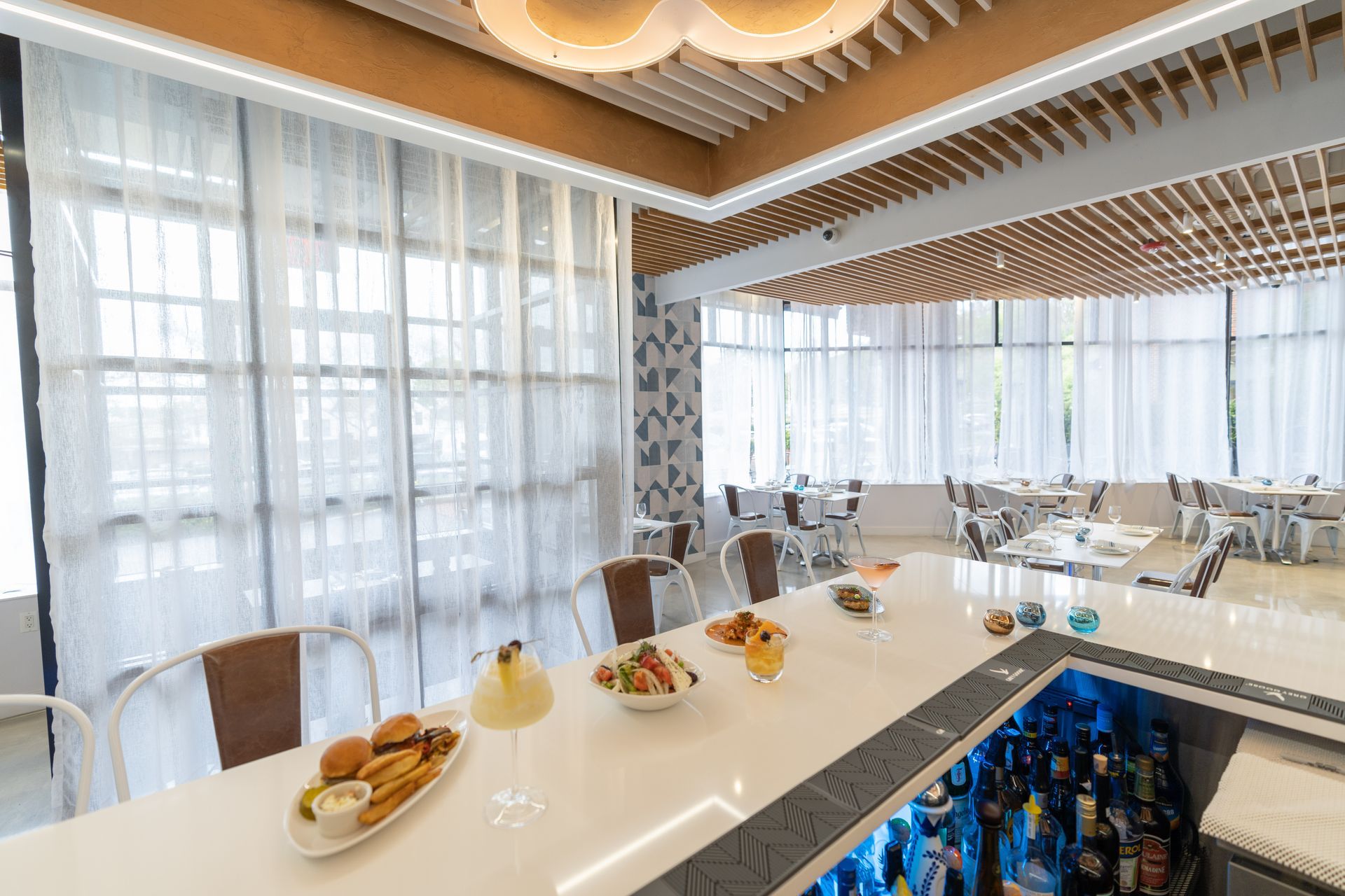 A restaurant with a bar and a lot of windows.