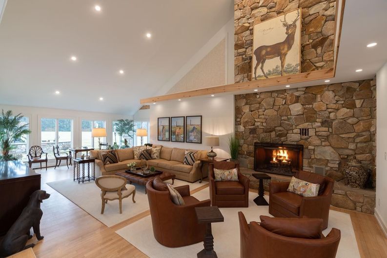 A living room with a fireplace , couch , chairs and a piano.