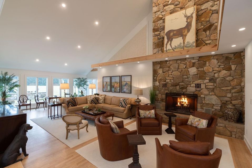 A living room with a fireplace , couch , chairs and a piano.