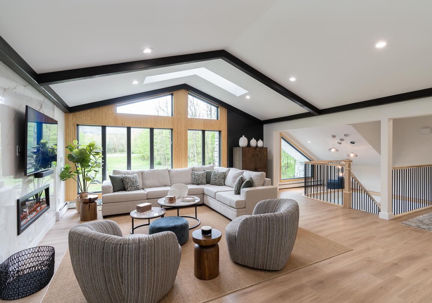 A living room with a couch , chairs , tables and a fireplace.