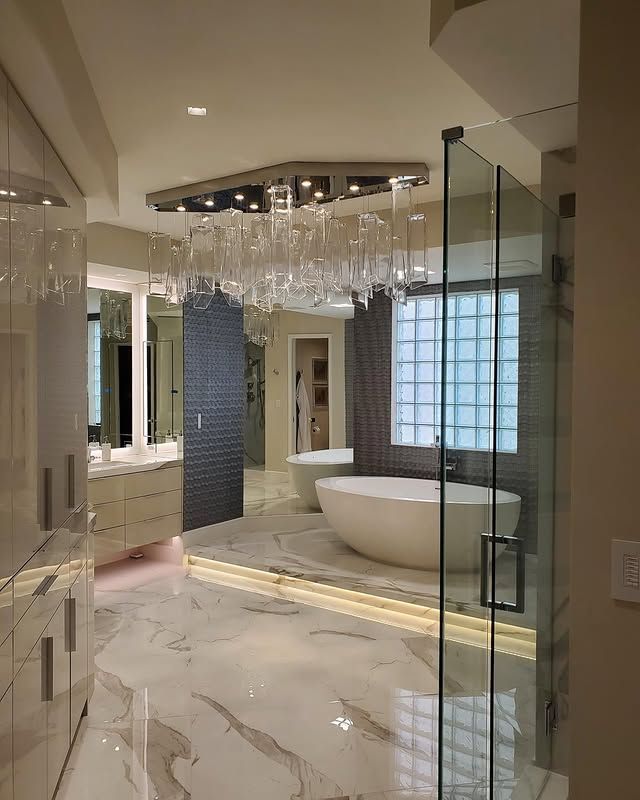 A bathroom with a tub and a chandelier hanging from the ceiling