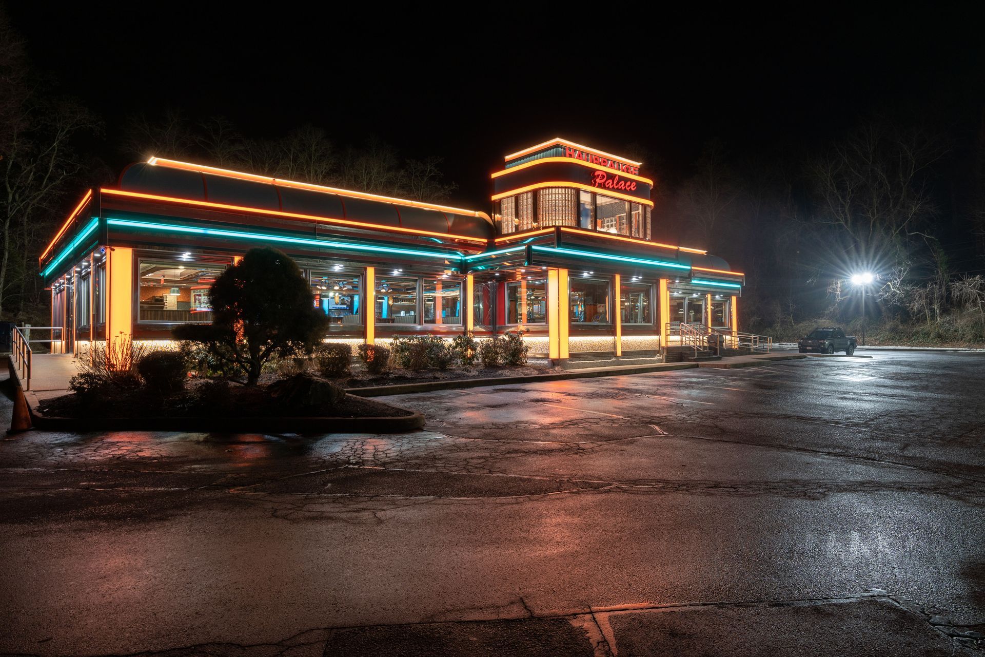 A diner is lit up at night in a parking lot.