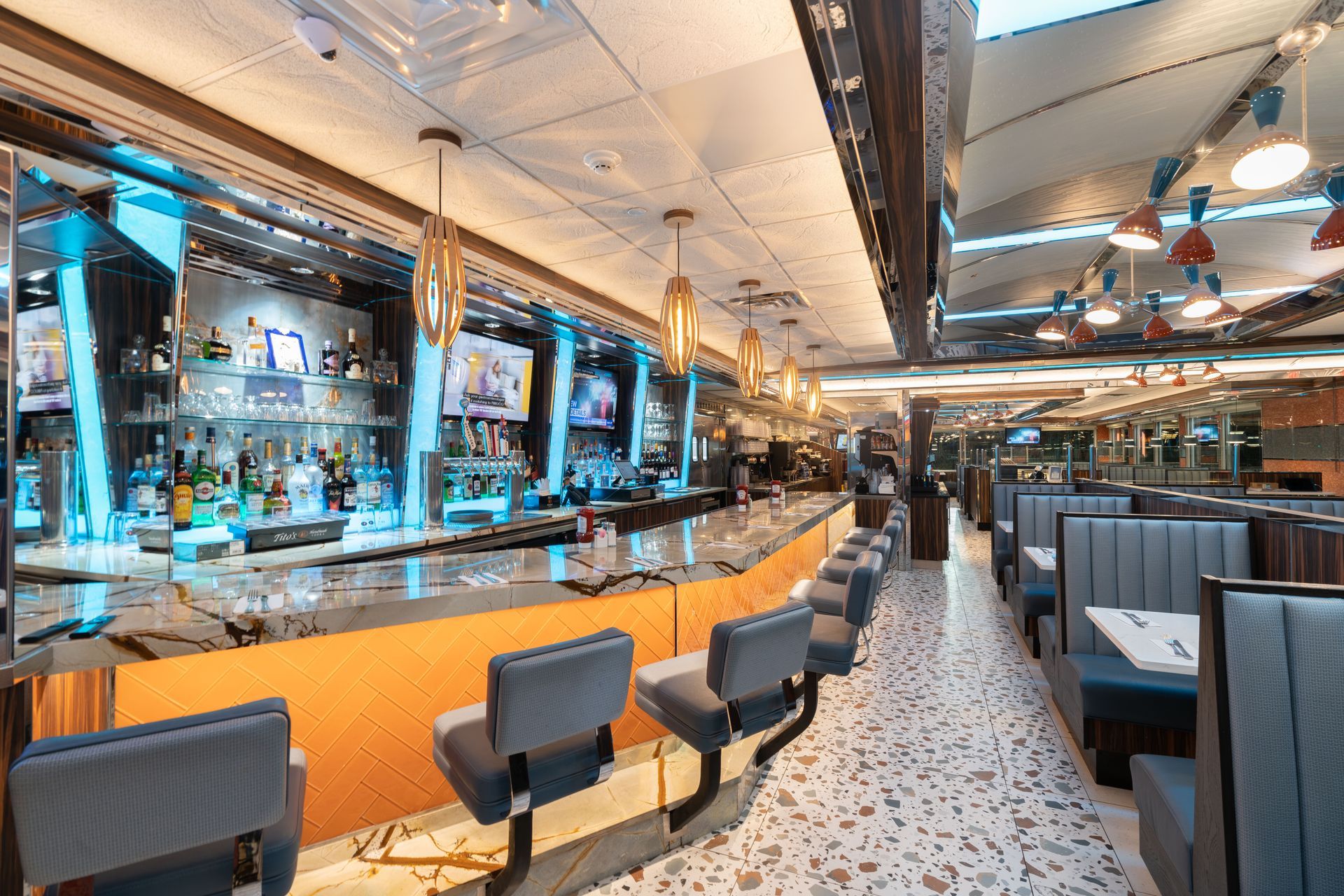 A diner with a long bar and tables and chairs.