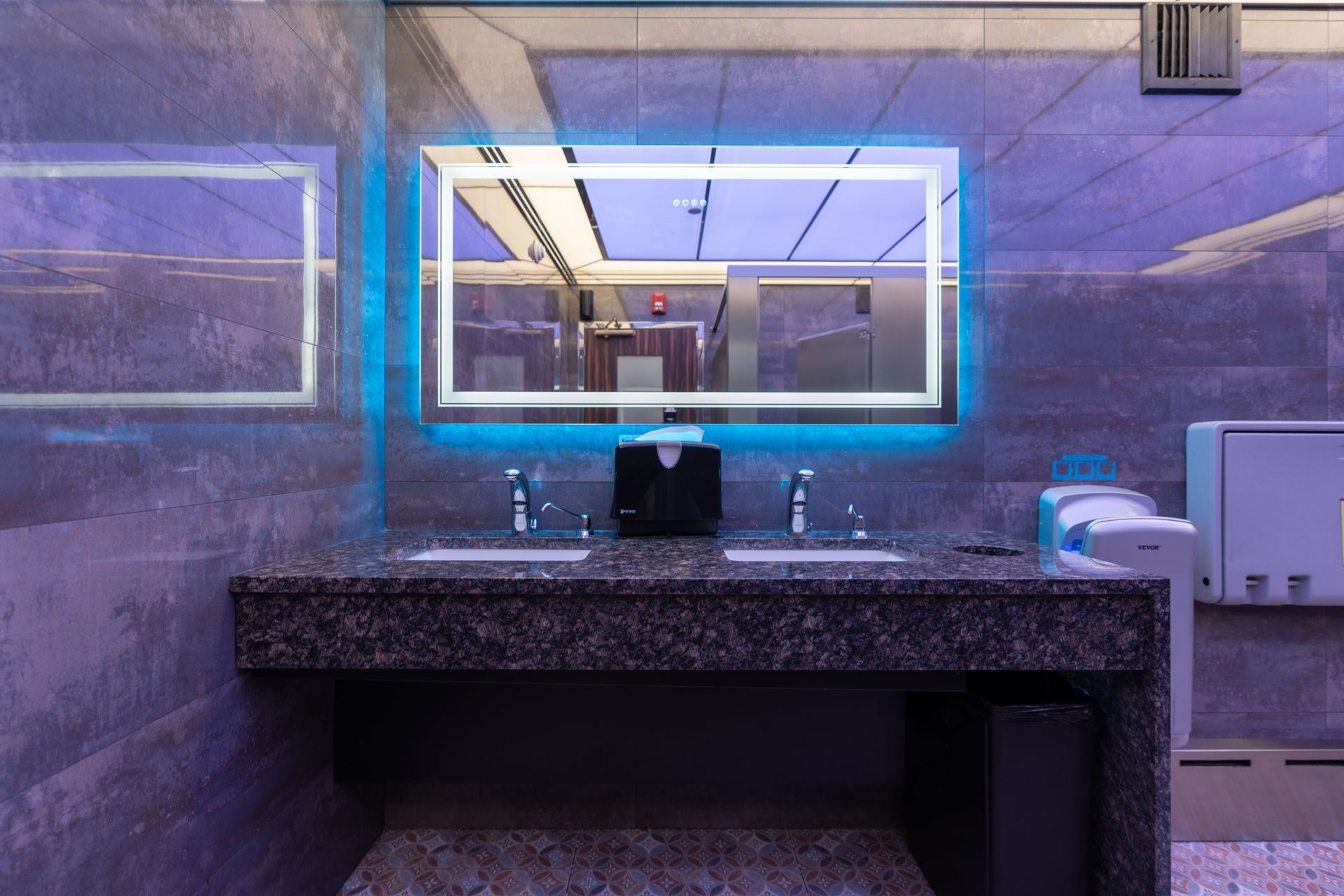 A bathroom with two sinks and a mirror.