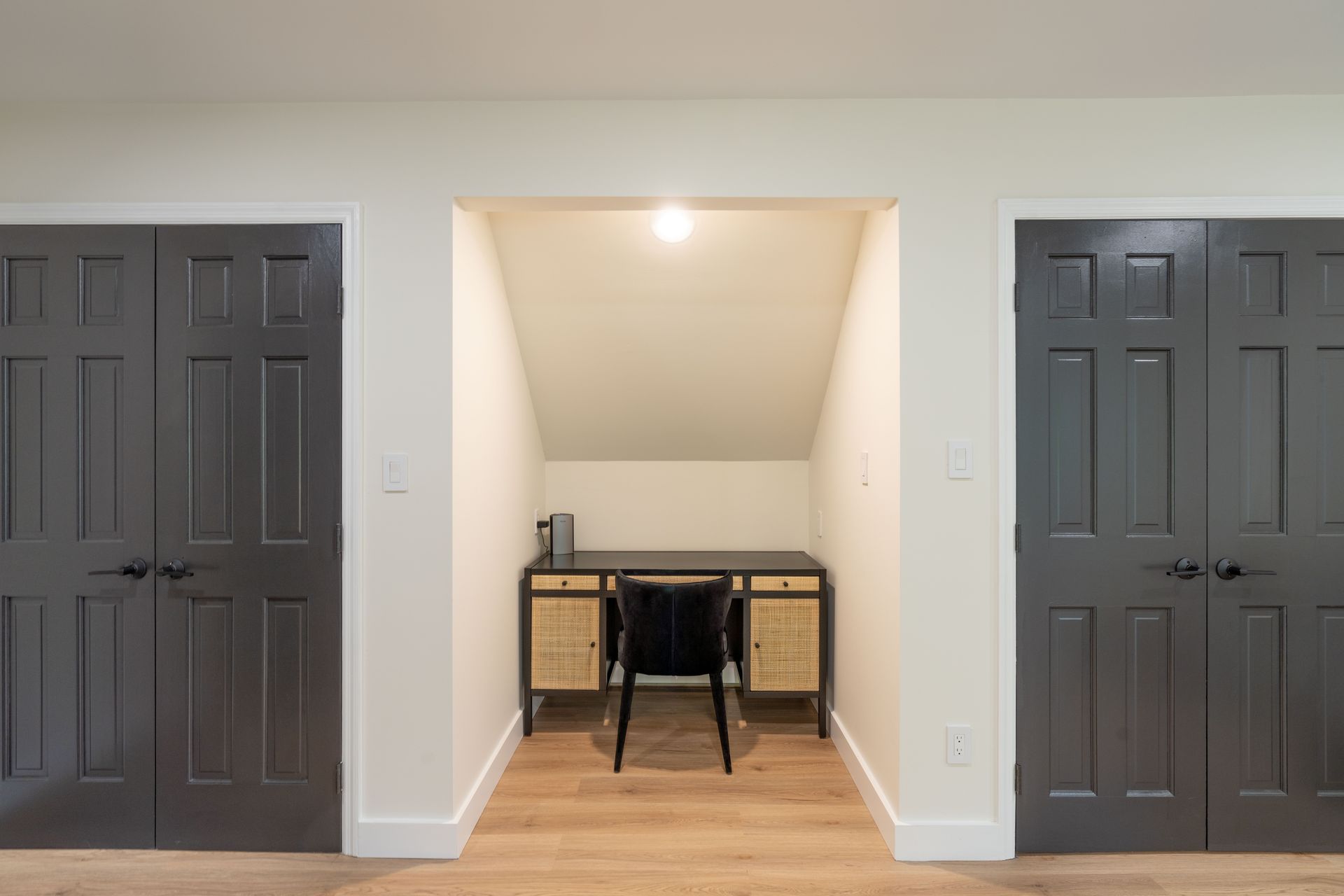 There is a desk and chair in the corner of the room.