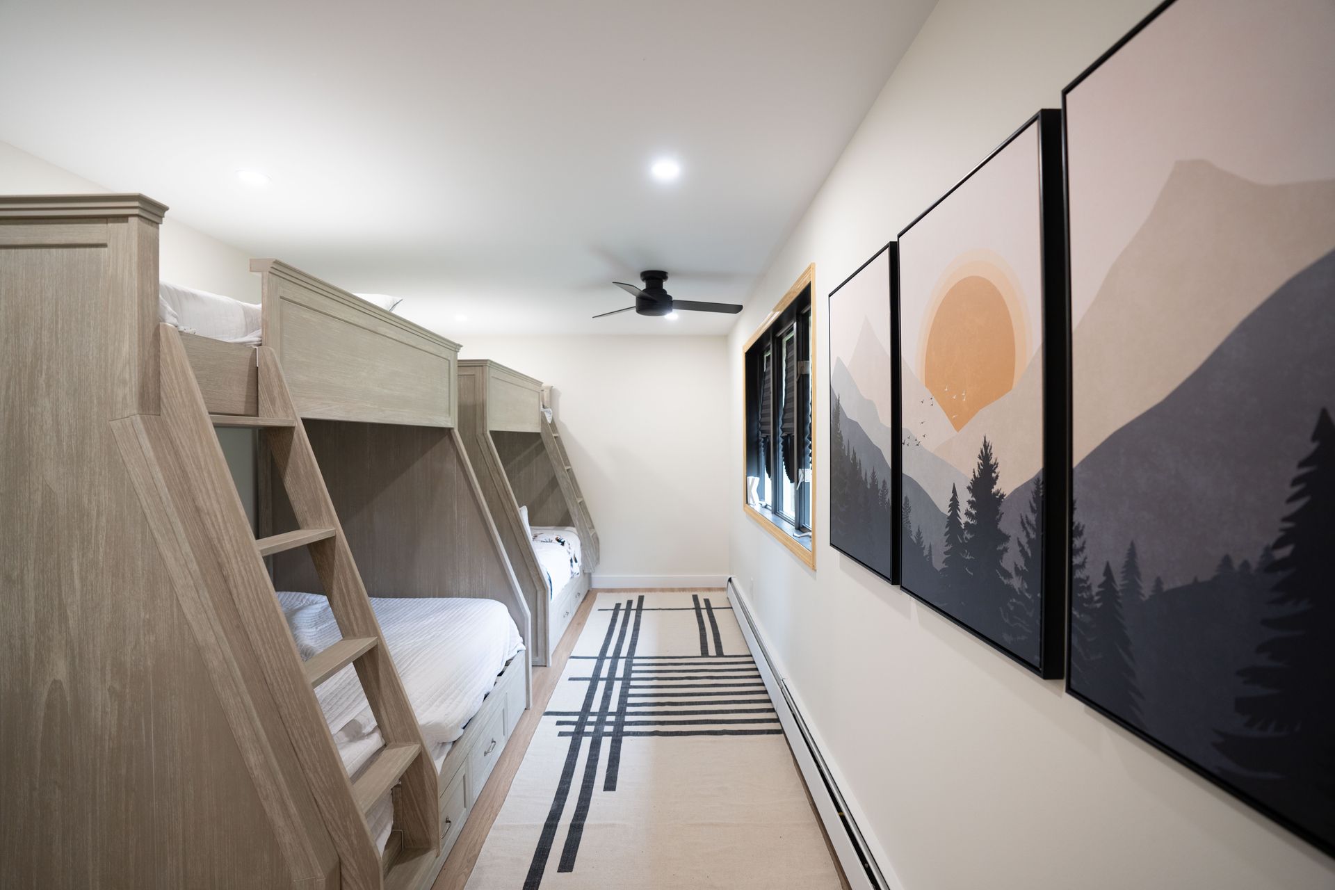A bedroom with bunk beds and paintings on the wall.