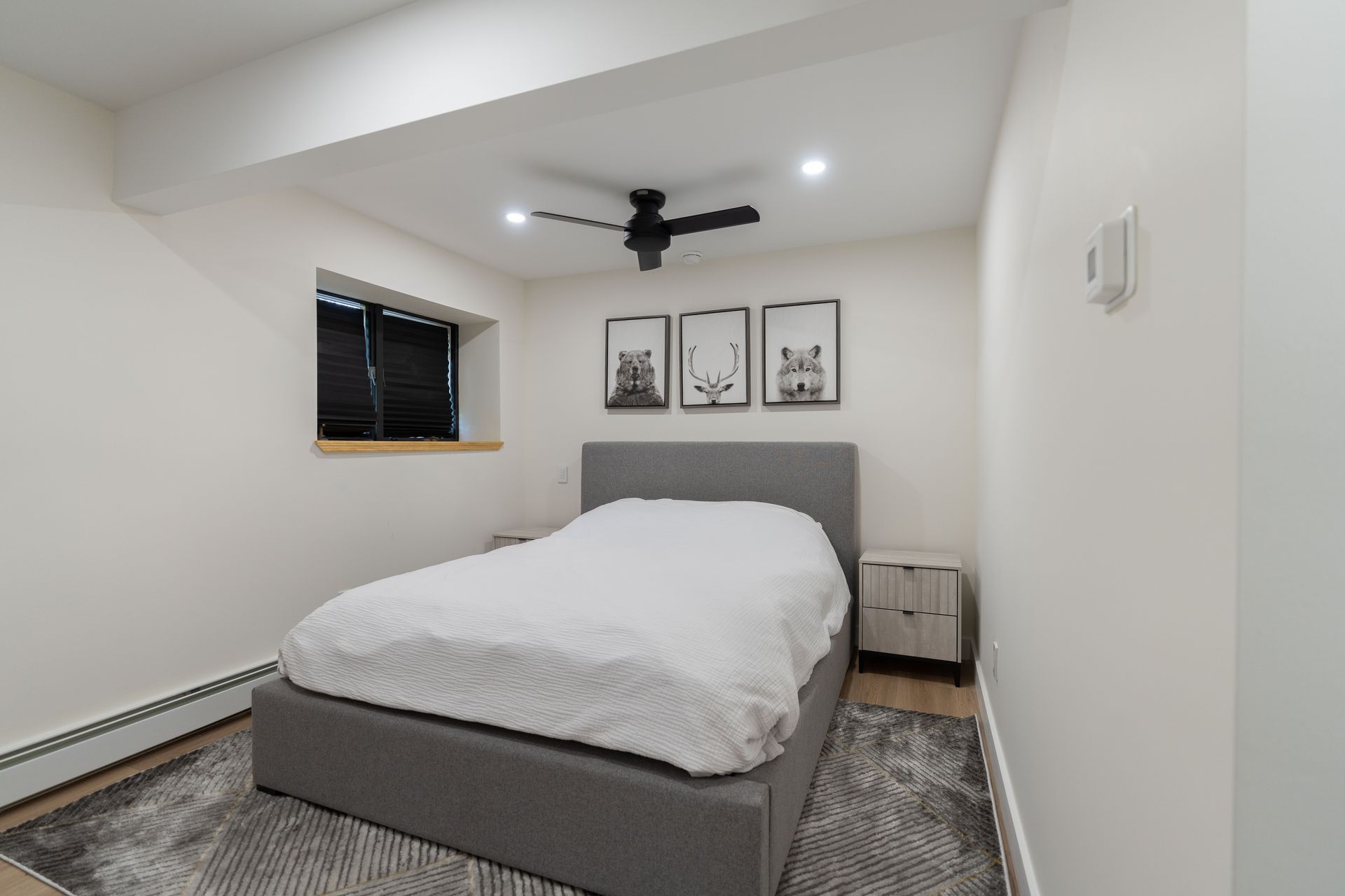 A bedroom with a bed and a ceiling fan.