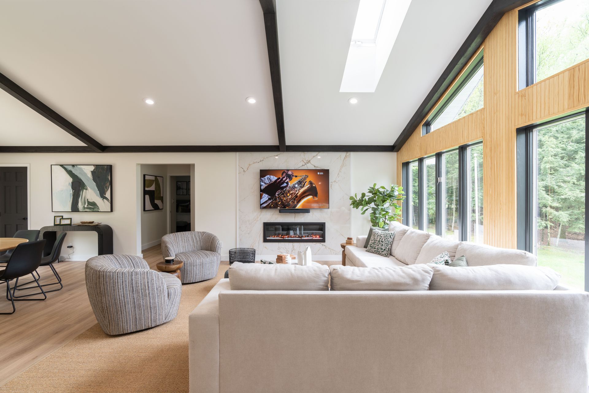 A living room with a couch , chairs , a television and a fireplace.