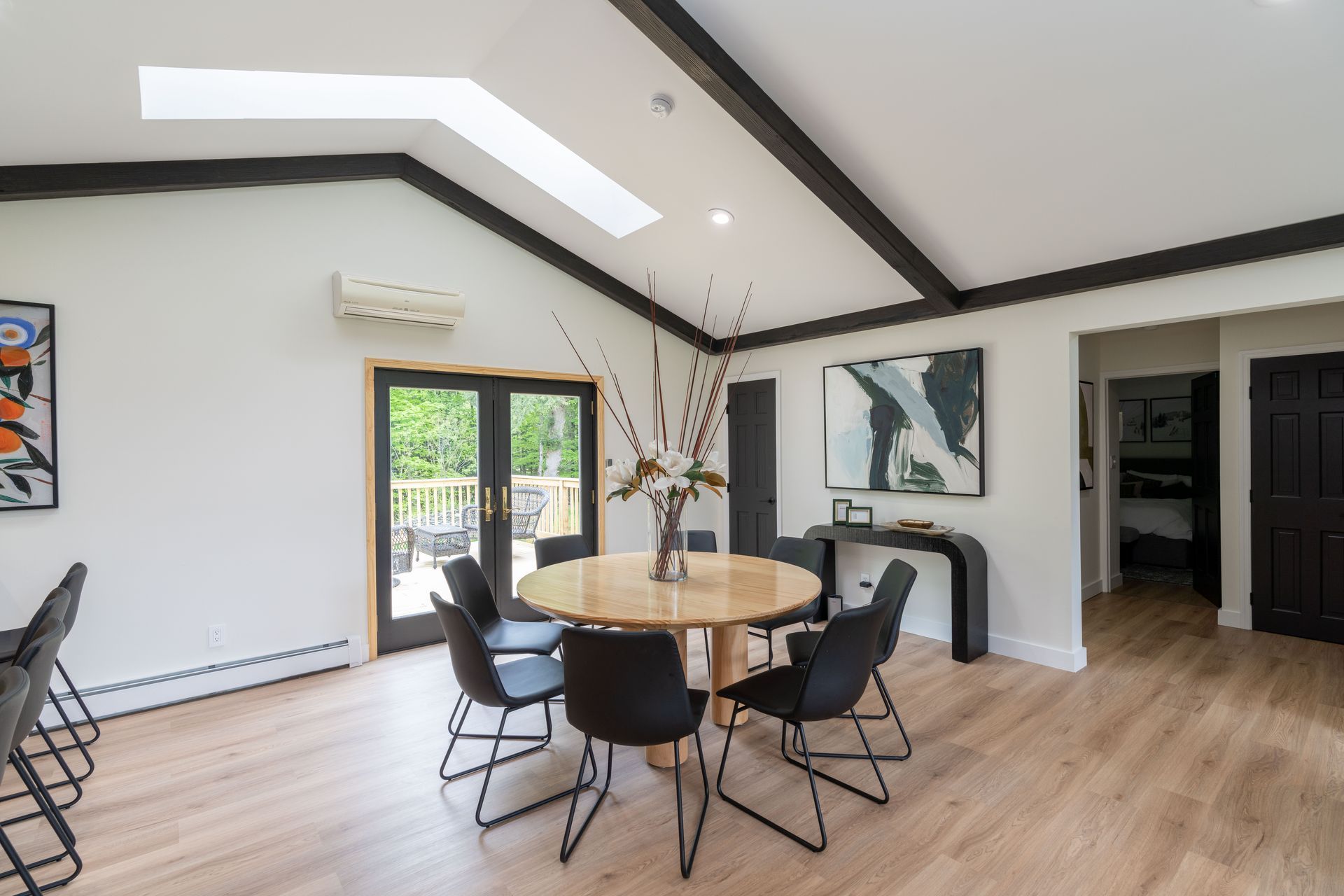 A dining room with a round table and chairs and a skylight.