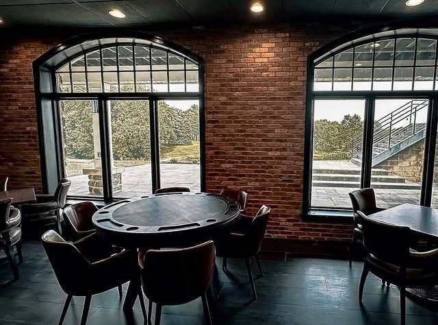 A room with a table and chairs and a brick wall.