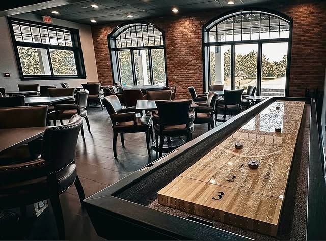 There is a shuffleboard table in the middle of the room.