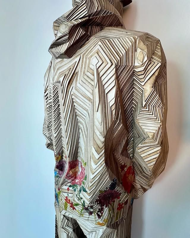 The back of a jacket with a hood is shown on a mannequin.