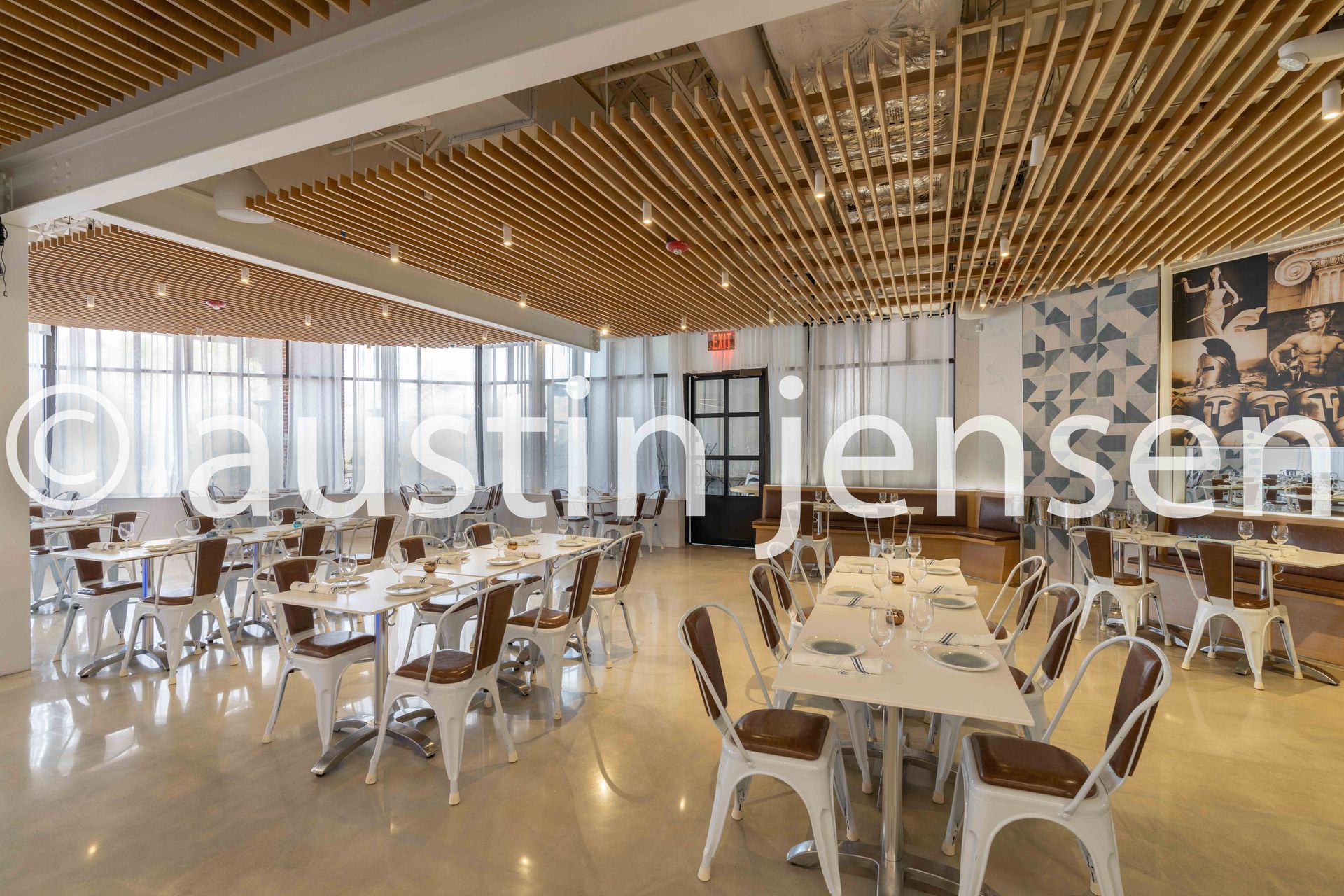 A restaurant with tables and chairs and a wooden ceiling.