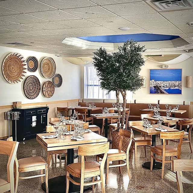 A restaurant with tables and chairs and a tree in the middle